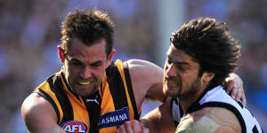 Geelong’s Max Rooke,a two-time premiership player with the Cats,battles for the ball with Hawthorn skipper Luke Hodge