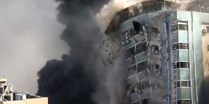 The building housing the offices of the AP and other media in Gaza City collapses after it was hit by an Israeli airstrike. 