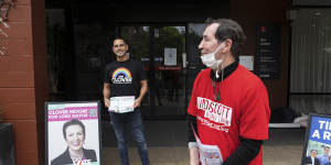 Sydney MP Alex Greenwich,left,who is Clover Moore’s campaign manager,and a Labor supporter hand out how-to-vote cards near a polling station.