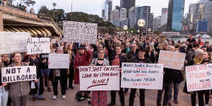 Protesters opposed to the Everest barrier draw being projected onto the Sydney Opera House display placards while at a forecourt rally.