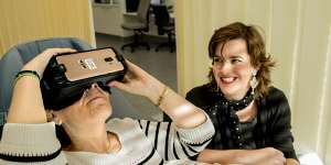 Prince of Wales Hospital is trialing VR therapy to help patients recover. Pictured is Theodora Michalopoulos wearing a VR headset as former patient Stefanie Ammann looks on.