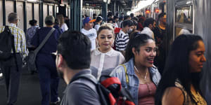 Commuters board the subway in New York,which still requires masks on trains and indoor stations. 
