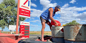 A farmer in Queensland tops up fuel barrels.