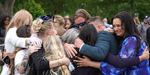 The Roberts family and survivors embrace each other during the vigil.