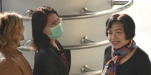 The former civil servant identified only by her first name Anchan,right,greets friends as she arrives at Bangkok Criminal Court to be sentenced.