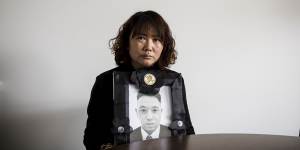 Lihong Wei holds a portrait of her husband,Xiaojun Chen,who was killed while working for a delivery company in Sydney.