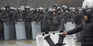 A demonstrator carries a police shield in front of police line during a protest in Almaty,Kazakhstan last week. 