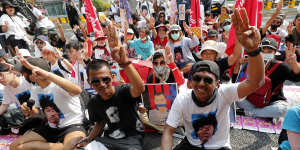 Pro-democracy activists gesture with a three-fingers salute,a symbol of resistance,as they arrive at the Attorney-General’s office in Bangkok,in March.