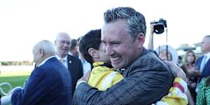 Jockey Craig Williams hugs trainer Adrian Bott.