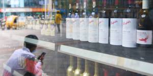 A man sits in front of a wine shop tht sells Australian wines in eastern Beijing’s Tongzhou district. 