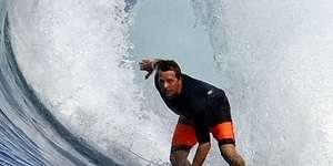 Surfer Brett Ryan rides a wave.