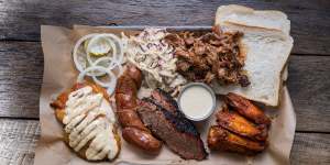 "Pitmaster selection"platter (clockwise from top right) pulled pork,buffalo hot chicken wings,brisket,house-made sausage,smoked chicken breast with Alabama-style white sauce,pickles and coleslaw.