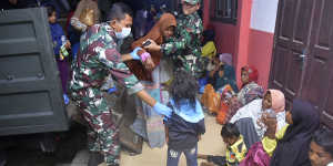Indonesian soldiers help Rohingya women and children at a temporary shelter after their boat landed in Pidie,Aceh province in December.
