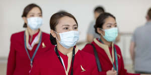 People wearing face masks to protect themselves from coronavirus are seen at Brisbane International Airport.