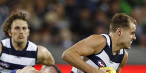 Jake Kolodjashnij of the Cats is tackled by North Melbourne’s Jack Mahony during their clash at GMHBA Stadium. 