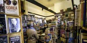 Joyce Saunders serves a customer in her bookshop in Castlemaine,Victoria,after lockdown ended in the regions. 