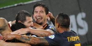 Harry Kewell is mobbed by teammates after scoring for Australia.