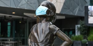 The Fearless Girl Statue in Federation Square dons a face mask.
