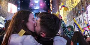 Visitors from Spain kiss as they celebrate in Times Square in New York shortly after midnight on January 1,2022.