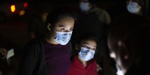 Fatima Nayeli,13,left,and her sister,Cynthia Stacy,8,answer questions from a US Border Patrol agent at an intake site after they were smuggled on an inflatable raft across the Rio Grande in Roma,Texas.