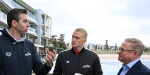 Australian Team Captain Grant Hackett (left) and swimmer Cody Simpson (centre) chat with NSW Minister for Tourism Ben Franklin (right) during the launch of the Duel in the Pool yesterday at Bondi Beach.