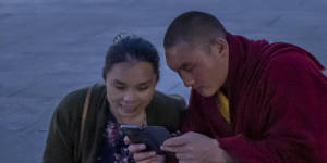 A monk and a woman look at a smartphone on a square in front of the Potala Palace in Lhasa,Tibet,as seen during a government organised visit for foreign journalists last year.