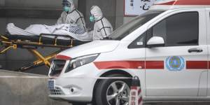 Medical staff transfer patients to hospital in Wuhan.