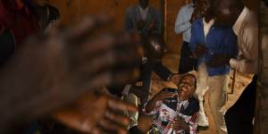 A religious group perform an exorcism on a woman in a small church in the Democratic Republic of the Congo.