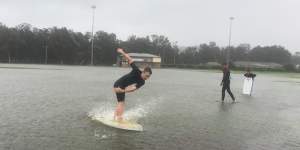 Kids have fun on their boards at flooded Nolan Reserve in Manly on Sunday.