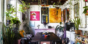 The dining room,with its “industrial vibe”,is a great place for people to gather. The table is a modified IKEA shelving unit. Paintings by Andrew Nakhla. 