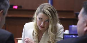 Amber Heard talks to her lawyers during the hearing.