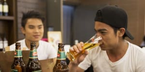 Customers drink Myanmar Beer,manufactured by Myanmar Brewery Ltd,at a bar in Yangon,Myanmar,before the coup.