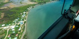 Flying into Saibai Island. Its $24 million sea wall was breached less than six months after its completion. During storm surges,the sea sluices under homes.