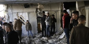 Palestinians look at the aftermath of an Israeli military raid on Jenin refugee camp.