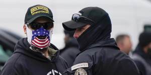 People wearing hats and patches indicating they are part of the Oath Keepers attend a rally in support of Donald Trump on January 5.