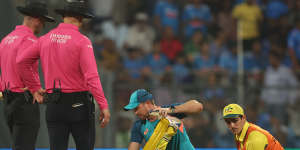 Glenn Maxwell is treated by Australian physiotherapist Ben Jones and 12th man Sean Abbott after collapsing with cramp.