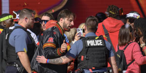 Police escort Kansas City Chiefs tight end Noah Gray and his teammates off the stage after a shooting following their victory parade and rally.
