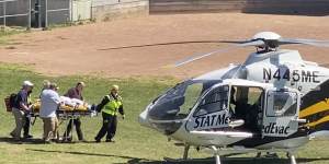 Salman Rushdie is taken on a stretcher to a helicopter.