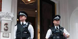 Metropolitan Police Officers wait outside the main door of the Ecuadorian embassy in London,where WikiLeaks founder Julian Assange is holed up.