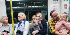 Tony Williams and wife Jacqui on board a metro train on Sunday with their daughters,Annika,left and Liesl.