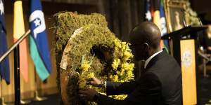Mourners lay wattle on two wreaths.