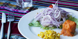 Peruvian fish ceviche is hidden under a hill of red onion.