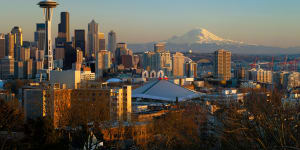 The Seattle city skyline at sunset with the Space Needle,downtown and Mount Rainier from Queen Anne Hill.
