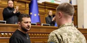 Ukrainian President Volodymyr Zelensky honours a soldier.