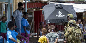 Australian Army soldiers talk with local citizens during a community engagement patrol through Honiara in November 2021. 