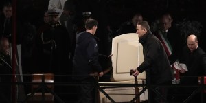 Vatican ushers carry away Pope Francis’ chair prior to the start of the Via Crucis (Way of the Cross) at the Colosseum on Good Friday.