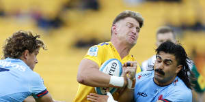WELLINGTON,NEW ZEALAND - MARCH 17:Jordie Barrett of the Hurricanes is tackled by Michael Hooper and Charlie Gamble of the Waratahs during the round four Super Rugby Pacific match between Hurricanes and NSW Waratahs at Sky Stadium,on March 17,2023,in Wellington,New Zealand. (Photo by Hagen Hopkins/Getty Images)