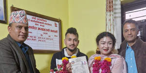 Same-sex couple Surendra Pandey,second left,and Maya Gurung,pose for a photograph with their marriage registration certificate at Dorje village council office in Kathmandu,Nepal.