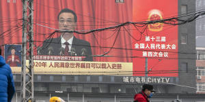 My way or the highway:Beijing commuters travel past a screen broadcasting Chinese Premier Li Keqiang speaking at the National People’s Congress. 