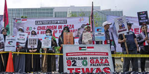 Protesters display posters and children’s shoes to represent children killed in the war between Israel and Hamas in Gaza,during a rally outside the US embassy in Jakarta,Indonesia,on Monday.